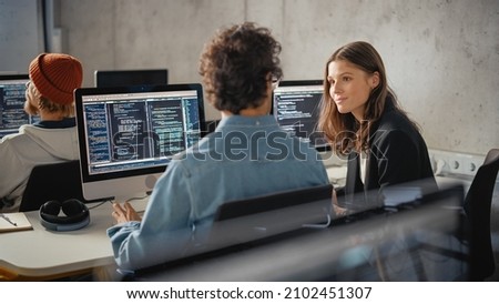 Smart Young Students Studying in University with Diverse Multiethnic Classmates. Scholars Collaborate in College Room on Computer Science Project, Writing Software Code in Successful Teamwork. Royalty-Free Stock Photo #2102451307