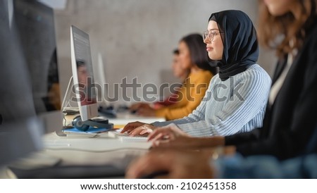 Happy Female Muslim Student Wearing a Hijab, Studying in Modern University with Diverse Multiethnic Classmates. Students Successfully Learn Computer Science, Writing Software Code.