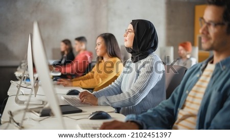 Smart Muslim Female Student in Hijab Studying in University with Diverse Multiethnic Classmates. Applying Her Knowledge to Acquire Academic Skills in Class