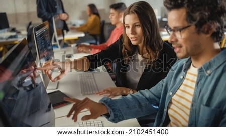 Diverse Multiethnic Group of Female and Male Students Sitting in College Room, Collaborating on School Projects on a Computer. Young Scholars Study, Talk, Apply Academic Skills and Knowledge in Class. Royalty-Free Stock Photo #2102451400