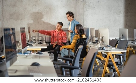 Diverse Multiethnic Group of Female and Male Students Sitting Together in Infographics Room, Collaborating on a College Project. Young Scholars Talking, Study Software Development or Computer Science. Royalty-Free Stock Photo #2102451403