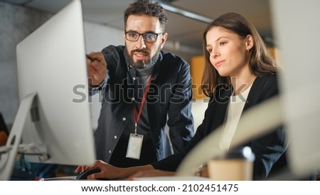 Lecturer Helps Scholar with Project, Advising on Their Work. Teacher Giving Lesson to Diverse Multiethnic Group of Female and Male Students in College Room, Teaching New Academic Skills on a Computer. Royalty-Free Stock Photo #2102451475