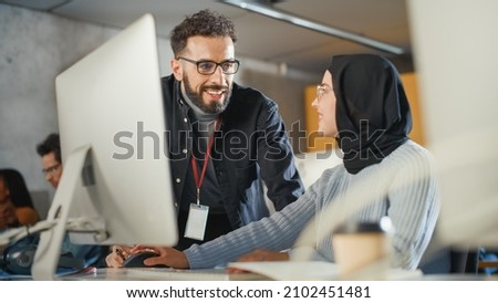 Lecturer Helps Scholar with Project, Advising on Their Work. Teacher Giving Lesson to Diverse Multiethnic Group of Female and Male Students in College Room, Teaching New Academic Skills on a Computer.