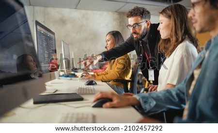Lecturer Helps Scholar with Project, Advising on Their Work. Teacher Giving Lesson to Diverse Multiethnic Group of Female and Male Students in College, Teaching Computer Science and Writing Code. Royalty-Free Stock Photo #2102457292