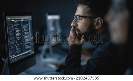 Handsome Smart Male Student, Studying in University with Diverse Multiethnic Classmates. He Works on Desktop Computer in College. Applying His Knowledge in Writing Code, Developing Software. Royalty-Free Stock Photo #2102457385