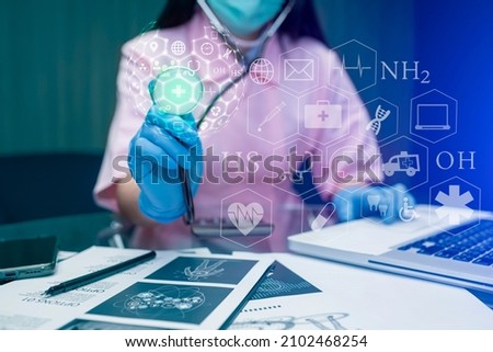 Female doctor holding a X-ray sheet with medical technology innovation interface icons, Healthcare And Medicine concept.