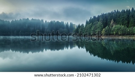 Beautiful scenic view of Savsat Karagol Black lake in Eastern Black Sea region with morning evaporation. Savsat Karagol lake is a large trout lake in the forest in Artvin, Turkey Royalty-Free Stock Photo #2102471302