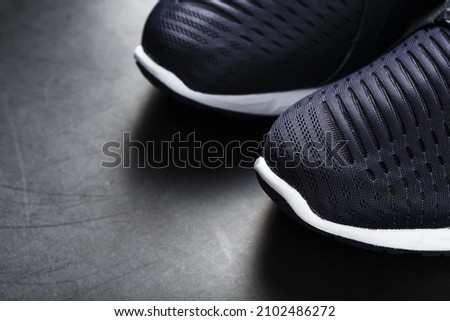 Black and white ultra-modern sports sneakers on a black background. Free space