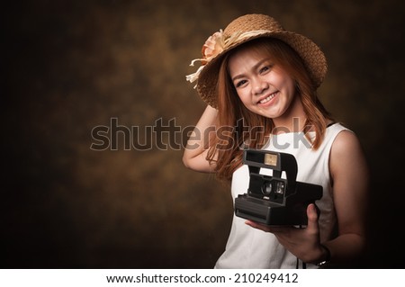 Young woman with her camera on a old background