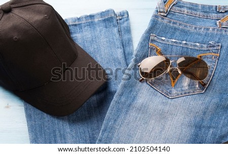 Jeans, cap and glasses on the table.