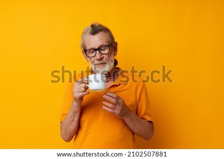 Portrait of happy senior man with a white mug of drink cropped view