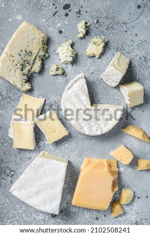 Assortment of cheese. Camembert, brie, blue cheese, parmesan. Gray background. Top view Royalty-Free Stock Photo #2102508241