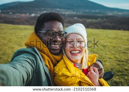 Handsome smilling happy couple friends hiker taking a photo selfie. Close up shot of two young cheerful lovers in the summer nice wood, embracing, posing for a selfie shot