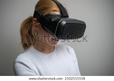 woman in white shirt wearing vr glasses, studio photo on white background
