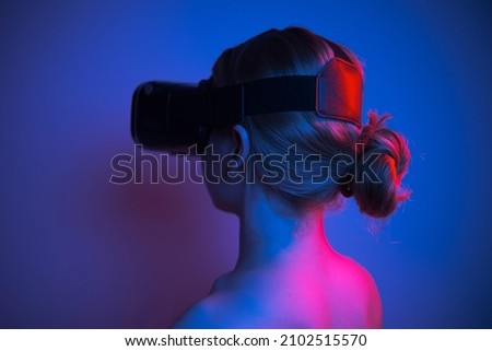 woman in white shirt wearing vr glasses, futuristic studio photo with colorful lights on plain background