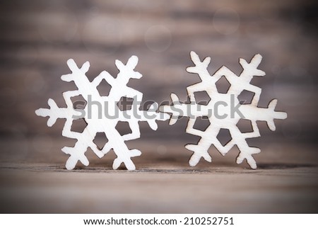Two Snowflakes on Wood with Bokeh, Dark and Shiny Christmas or Winter Background