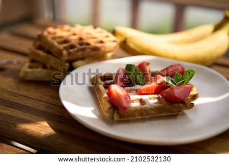 Waffles with strawberries, bananas and honey. High quality photo