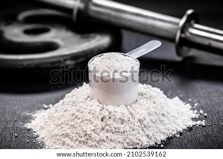 Amino acid supplement for sports use, creatine in a measuring spoon, hmb, bcaa, amino acid or powdered vitamin. sports nutrition concept Royalty-Free Stock Photo #2102539162