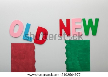 The words old and new made of colorful alphabet letters with green and red torn paper.