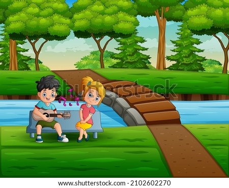 Young couple playing guitar and singing by the river