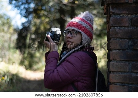 Young woman using camera in the middle of nature