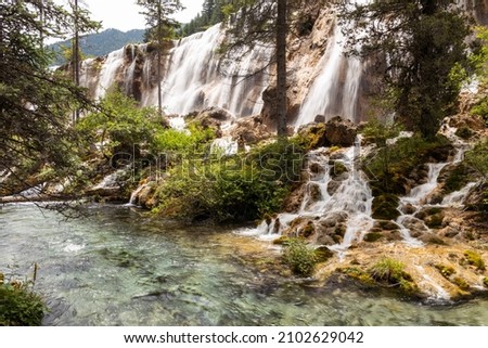 Wallpaper picture of the Nuorilang waterfall on a sunny day with river on the front, Jiuzhaigou Valley Scenic Area, Sichuan, China. UNESCO World Heritage site in China 