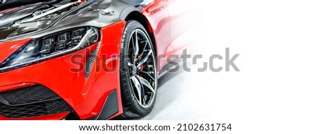 Front headlights of red modify car on white background, copy space
