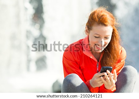 Portrait smiling beautiful city lifestyle woman on phone, pretty young girl texting on smartphone, isolated waterfall  background. Positive facial expression, emotions, communication concept.