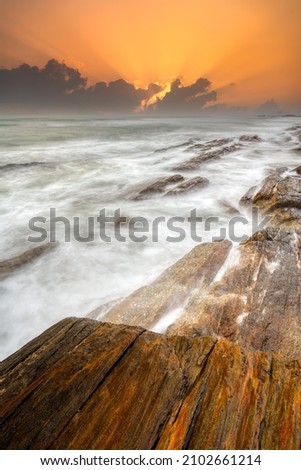 waves and rocks in sunrise in long exposure
