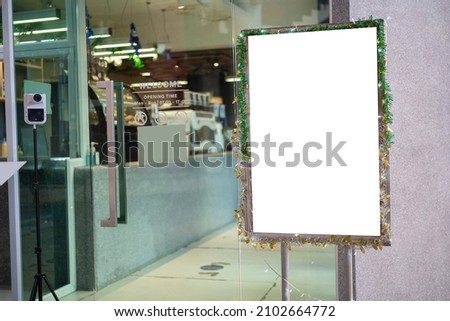 White poster mockup with black frame stand in front of blurred cafe restaurant background for displaying or presenting promotional product ideas.
