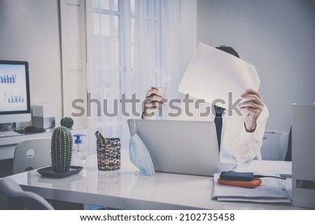 Business man with surgical masks working in the office during lockdown for coronavirus covid-19. Male sitting at the desk works with laptop at home. Health care, quarantine, remote working concept.