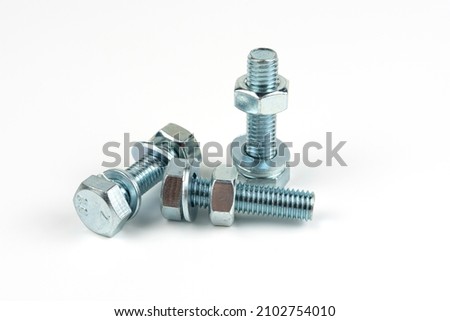 Several large silver metal bolts. Bolts, nuts and washers on a white background close up