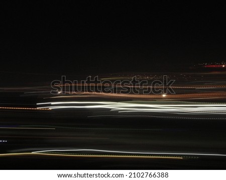 Several Lines of different colors and sizes moving in the dark. Camera movement Royalty-Free Stock Photo #2102766388