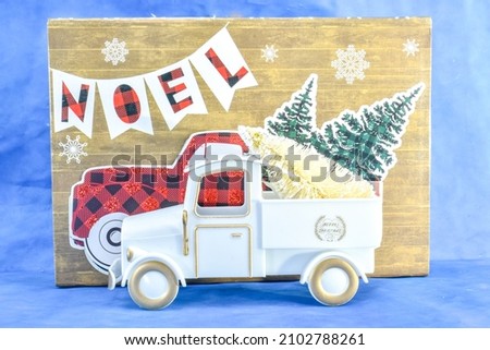 A White Vintage Truck with White Christmas Tree with Noel Background
