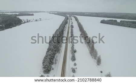 Road and trees in winter with drone