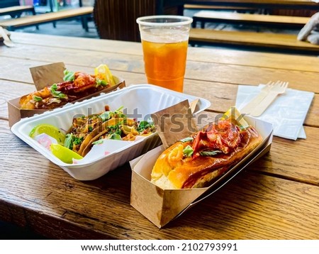 Market street food, Lobster claw roll bun and tacos served with sage herbs and lemon in a paper bowl Royalty-Free Stock Photo #2102793991