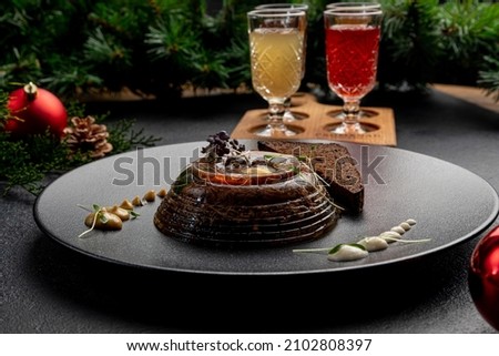 aspic served with black bread on a dark plate with mustard and horseradish on a dark Christmas background