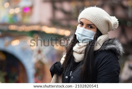 Peruvian woman wear an anti-virus protection mask outside at a Christmas Market, from corona COVID-19 and SARS cov 2 infection, front of blurred lights