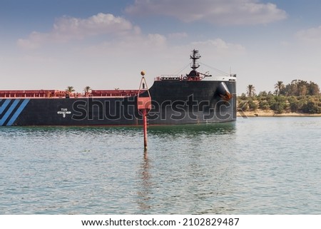 Red beacon and cargo ship. Suez canal, Ismailia, Egypt