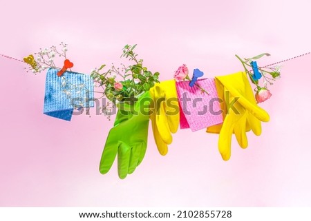 Creative bright spring cleaning concept. Tools, bottles, accessories for cleaning house with spring flowers and leaves hang on clothesline, box, bright sunny light copy space  Royalty-Free Stock Photo #2102855728