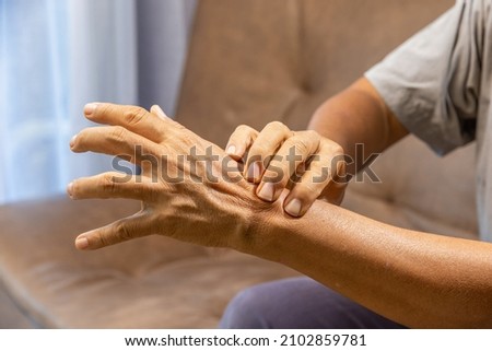 Senior man hand suffering from joint pain with gout inflammation