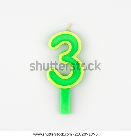 Green yellow number 3 candle isolated from white background.