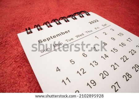 September 2022 - spiral desktop calendar against red handmade paper, low angle macro shot, time and business concept Royalty-Free Stock Photo #2102895928