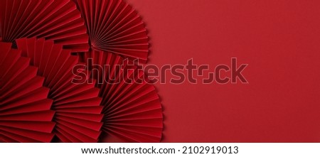 Chinese new year festival or wedding decoration over red background. Traditional lunar new year paper fans. Flat lay, top view, banner Royalty-Free Stock Photo #2102919013