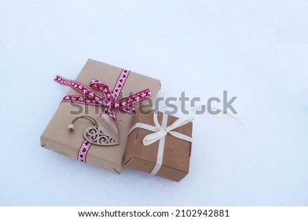 gift boxes tied with ribbons in the snow. valentine's day card, gift in love, romantic background.
