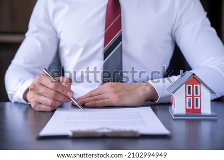Businessman is signing a contract to make insurance and buy a successful house project , home insurance ideas home and land mortgage