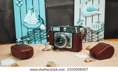 retro camera on the sand between seashells against the backdrop of scenery