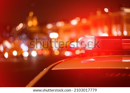 Police car red color emergency light (siren) at the night city lights background. 