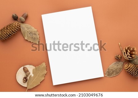 Autumn composition, Blank paper cards Mockup with dried leaves.  and pine cones on brown background. Flat lay, top view with copy space