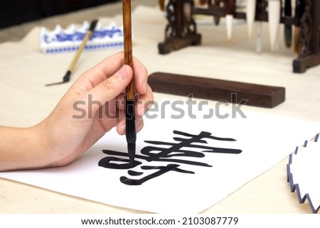 Traditional Chinese calligraphy Master writing a character translation means longevity. Asian art equipment and tools